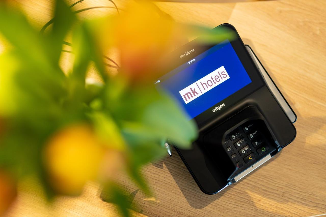 mk hotel tirana Rinas Eksteriør billede A mobile phone with the MK1Hotels logo on the screen
